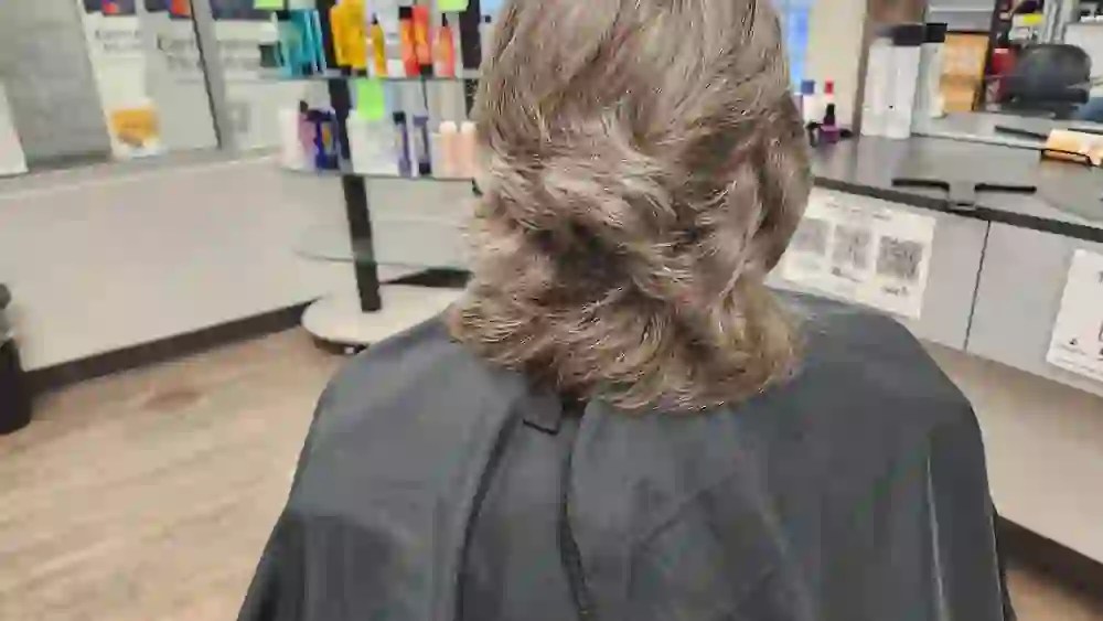Rear view of a medium-length layered haircut with soft feathered movement and a clean perimeter.